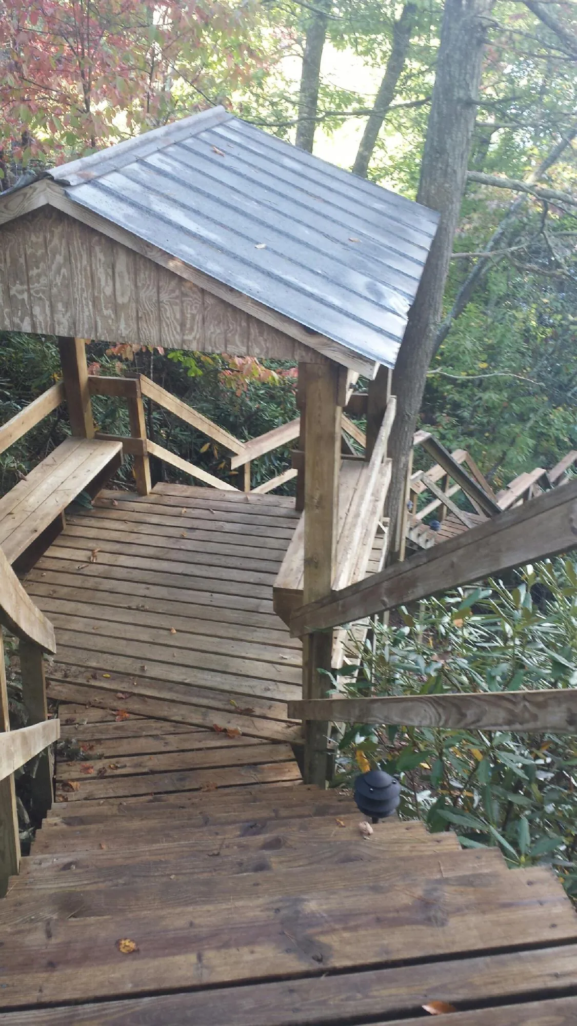 Metal roofed shelter over wooden steps on a wooded walkway — Skylight Repair & Installation work by our crew in Williamsburg